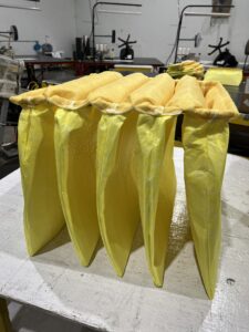 Four yellow bags kept on a white floor inside a firm