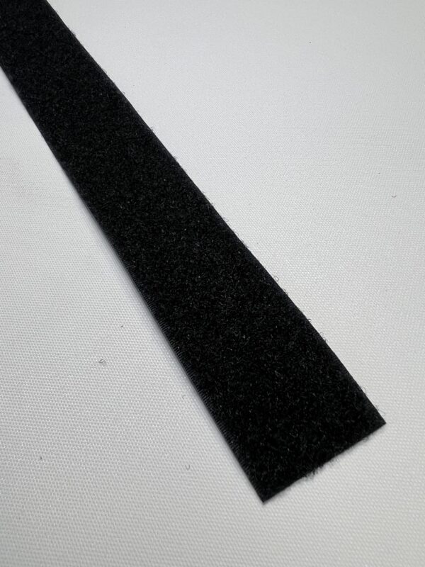 A black strip of fabric on top of a white surface.