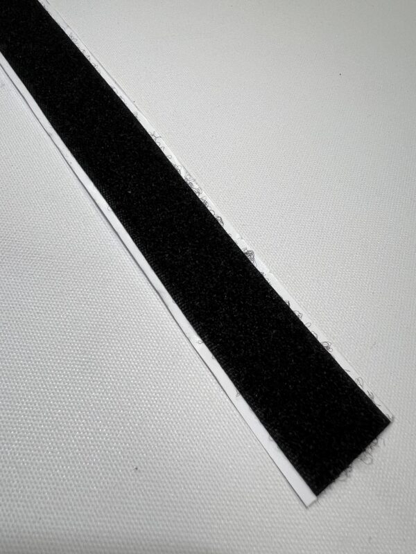 A black strip of tape on top of a white surface.